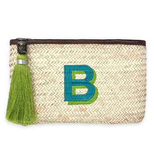 A clutch made from Hand woven from Palm Leaf in Morocco and and features a leather trim and an inside pocket. Monogramed with a large shadow font letter