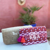 Ikat Wash Bag in reds colour, shot in front of a terracotta coloured wall