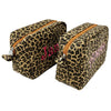 Two Leopard print wash bags with pink monograms on