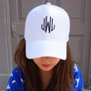 A Girl wearing a White Baseball Cap with large monogram with three letters