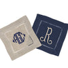 One Beige Line Coaster with a large, navy, three letter monogram. Behind is a Navy Linen Coaster with a large, single letter monogram