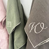 A close up of the Olive and Brown tea towels with an embroidered monogram on each
