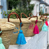 Multiple Hand Baskets made from Palm leaves with leather handles. Each has a monogram in a different colour 