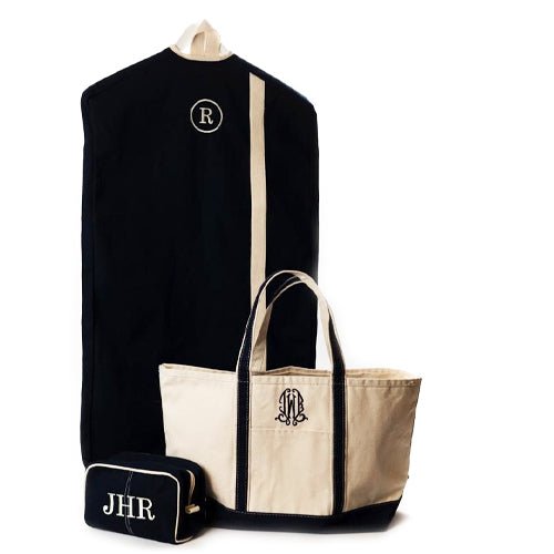 Canvas Garment Bag in black with a cream coloured stripe, with a single letter monogram. In front is our black large Maine Boat Tote and a Black wash bag - Initially London