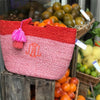 Orange and Pink, Sustainable braided jute Tote Bag. A large orange monogram on the front. The bag is placed outside a market stall