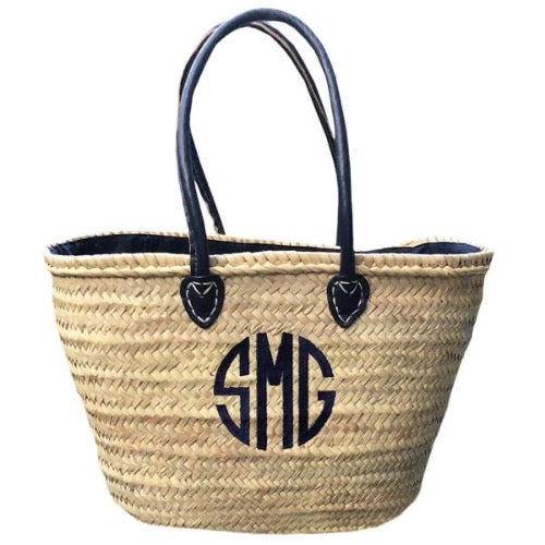  Market Basket which are handwoven in Morocco using palm leaves which are both strong and durable, the lining is 100% cotton dyed navy to match the straps. A large circle monogram on the front