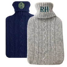 Navy and Grey Cashmere Hot Water Bottles. Navy, behind, has a three letter circle monogram, and Grey has a two letter monogram